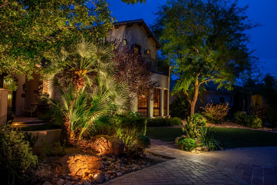 An image of a beautiful front yard that is lit with outdoor lighting fixtures.